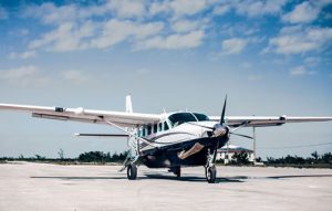 A small propeller plane parked on an airport runway, offering daily flights to Andros and Chub Cay in the Bahamas.