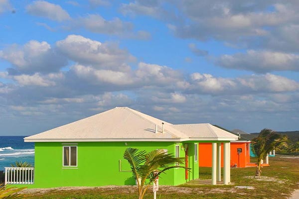 Two brightly colored houses next to the Staniel Cay ocean.