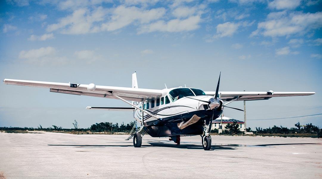 Small airplane parked on an airstrip under a clear blue sky.