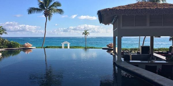 a-swimming-pool-next-to-the-ocean-and-palm-trees-in-staniel-cay-bahamas