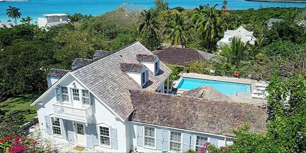 an-aerial-view-of-a-white-house-with-a-pool-in-andros