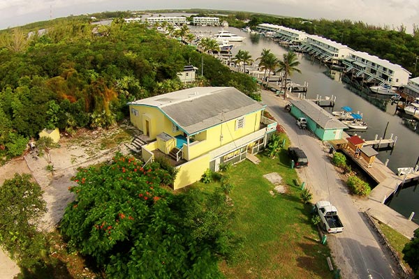 makers-air-offers-daily-flights-to-staniel-cay-where-you-can-enjoy-an-aerial-view-of-a-yellow-house-near-a-dock